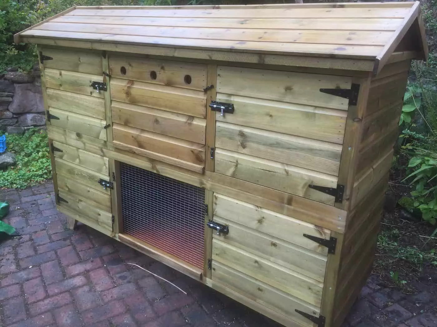 The 6ft British Giant XL Double Rabbit Hutch features multiple compartments, a mesh section, and provides ample space on a brick patio—making it perfectly suitable as a rabbit hutch for 2 rabbits.