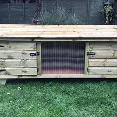 6ft British Giant XL Rabbit Hutch featuring a large wooden design with a hinged roof and wire mesh front, set on a grassy lawn.