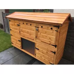 The 5ft British Giant Large Double Rabbit Hutch with Upstairs Winter Protection is perfect for a patio, offering multiple compartments and metal mesh paneling.