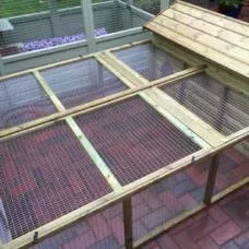 The 5ft British Giant Large Rabbit Hutch + 6ft Run with its wire mesh roof and spacious area is elegantly placed on the red brick patio.